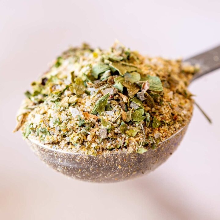 extreme close up on a spoonful of garlic and herb seasoning, showing clearly the mixture of herbs.