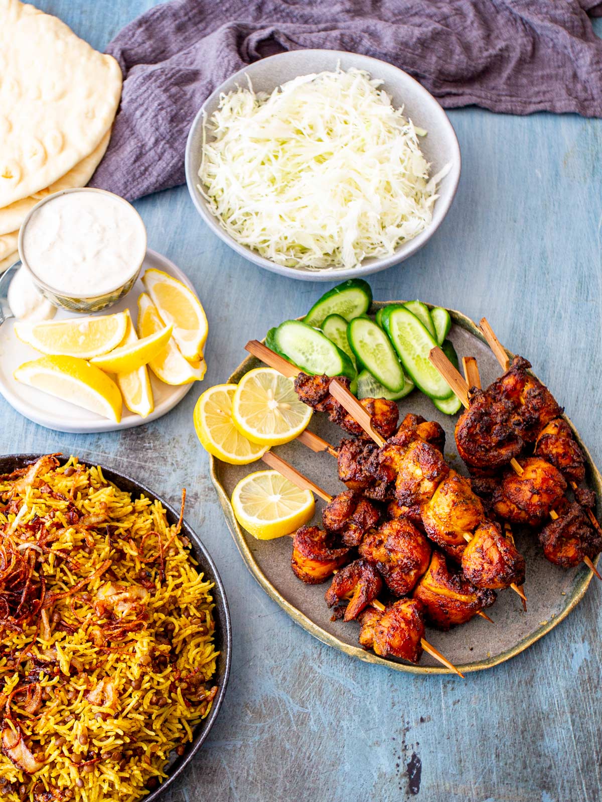 A full table setting featuring air fryer chicken shawarma skewers, fresh salad, creamy yogurt sauce, Mejadra, and warm flatbread.