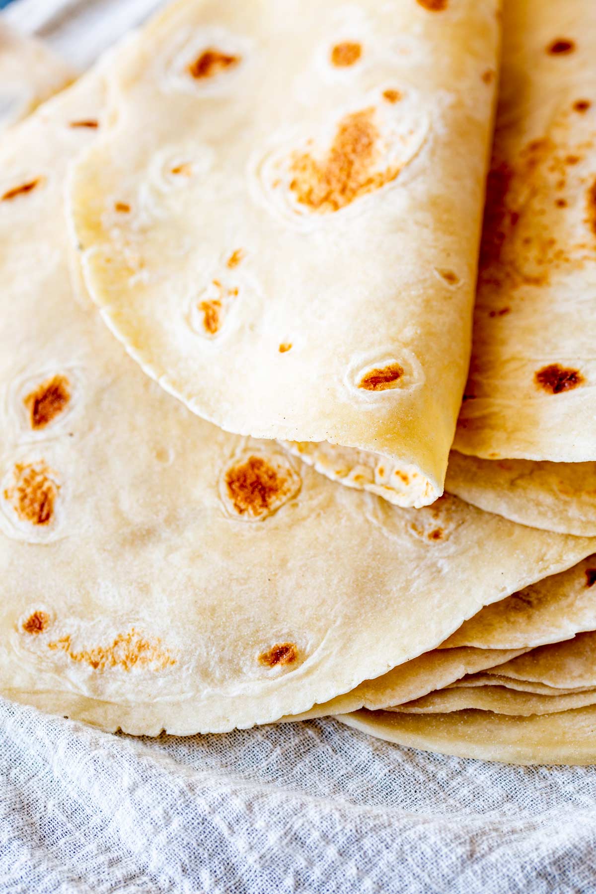 a stack of flatbreads with golden colour on a linen napkin