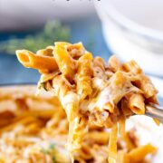 Pin Image: Spoon scooping cheesy French onion pasta with text overlaid