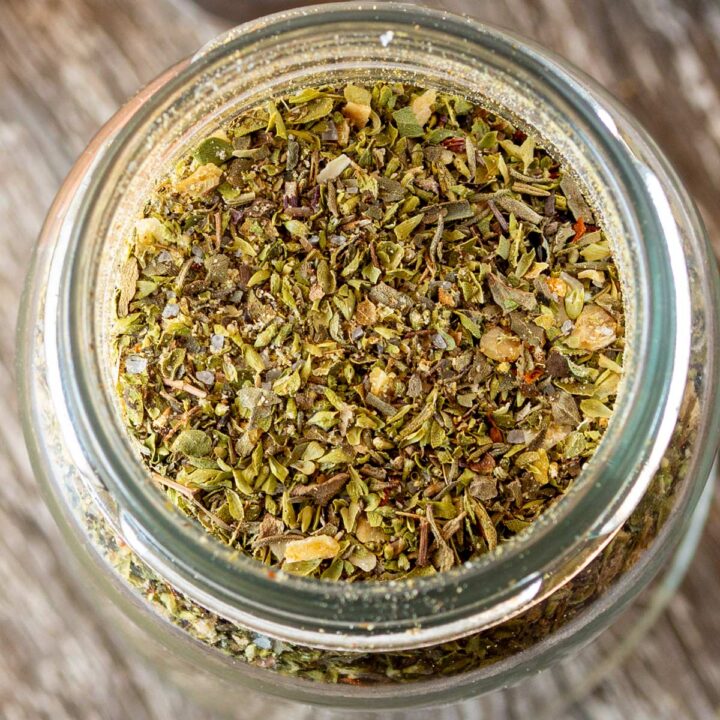 Ultra close-up of dried herbs and spices in the pizza seasoning mix, showing texture and detail