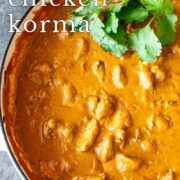 Pin Image: Creamy Chicken Korma cooked in a cream cast iron pan with text overlaid