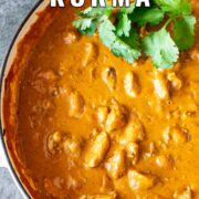 Pin Image: Creamy Chicken Korma cooked in a cream cast iron pan with text overlaid