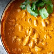 Pin Image: Creamy Chicken Korma cooked in a cream cast iron pan with text overlaid