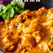 Pin Image: Close-up of golden Chicken Korma in black bowl with text overlaid