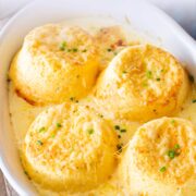 Pin Image: Four cheese soufflés in rustic white baking dish with text overlaid