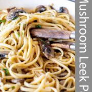 Pin Image: Mushroom and leek pasta in a cream cast iron pan serving tongs and text overlaid