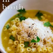 Pin Image: Ditalini pasta with broth in a white bowl with text overlaid