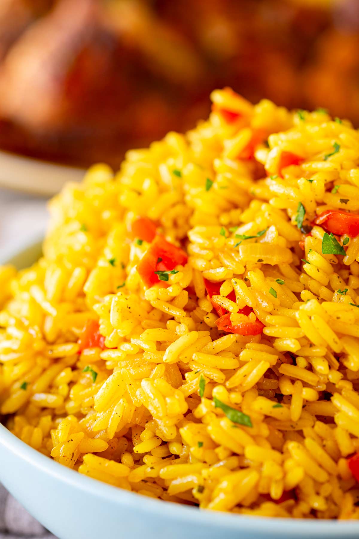 A close-up of homemade Portuguese rice in a blue bowl, showing the light, fluffy grains.