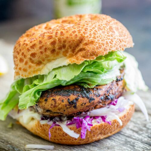 super close up of a Juicy Peri Peri Chicken Burger in a bun with lettuce