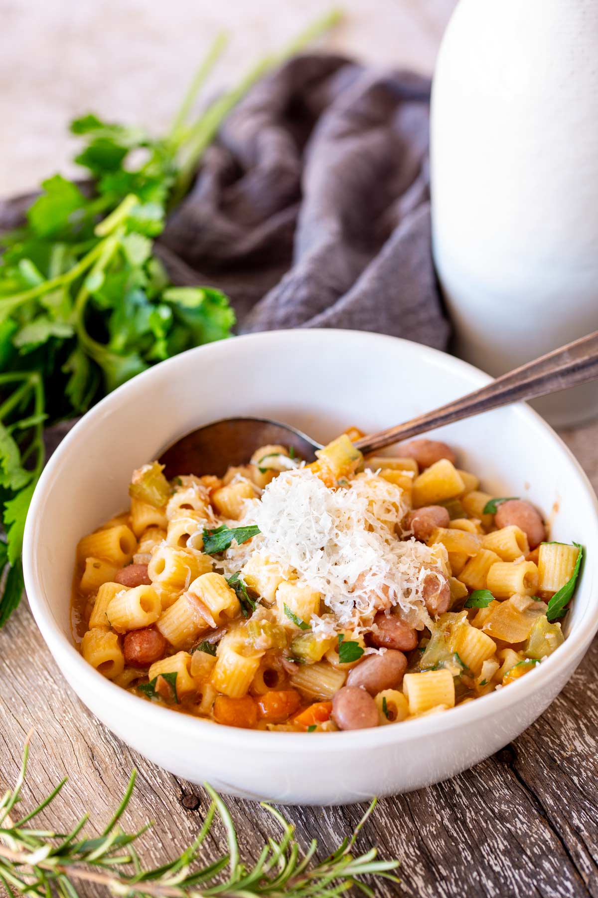 a bowl of soup with a spoon in it and a grey napkin in the background