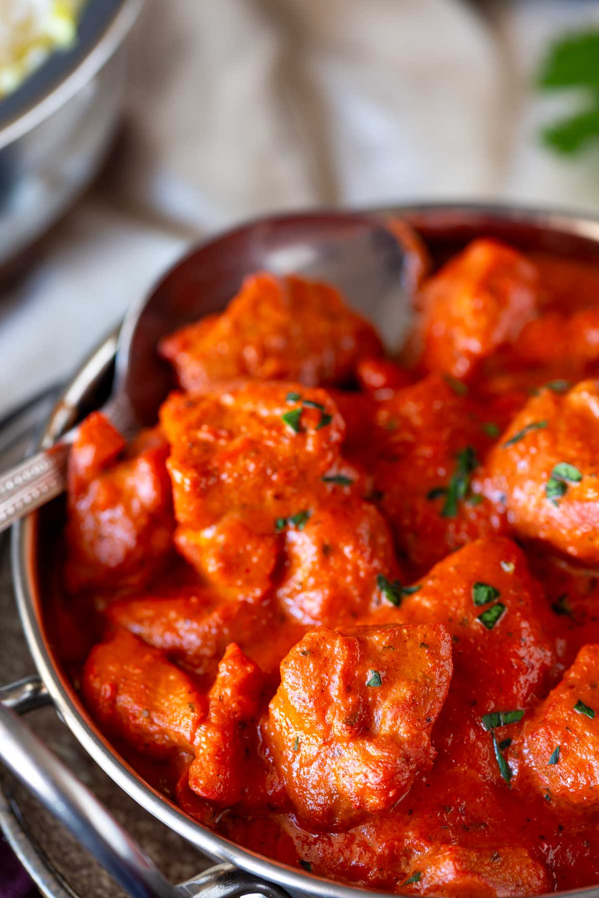 a spoon in a dish of bright red curry
