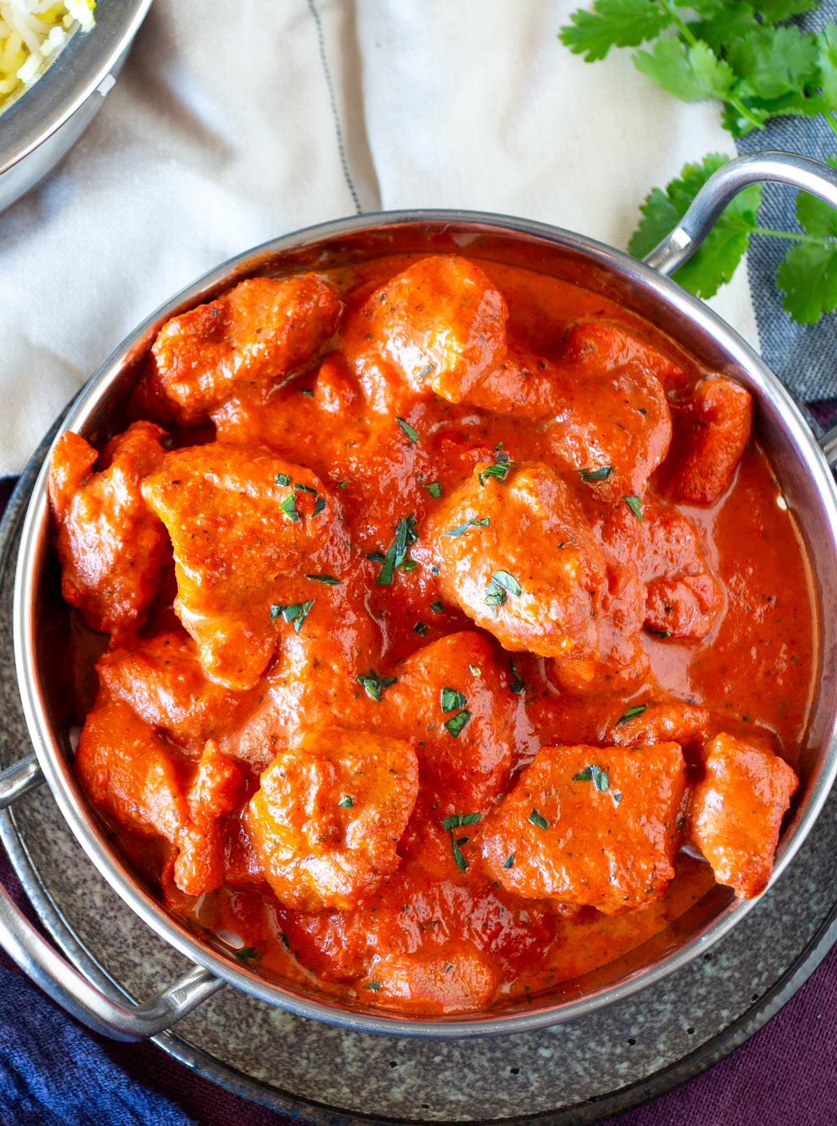 Close-up of homemade Chicken Chasni served in a traditional metal curry dish