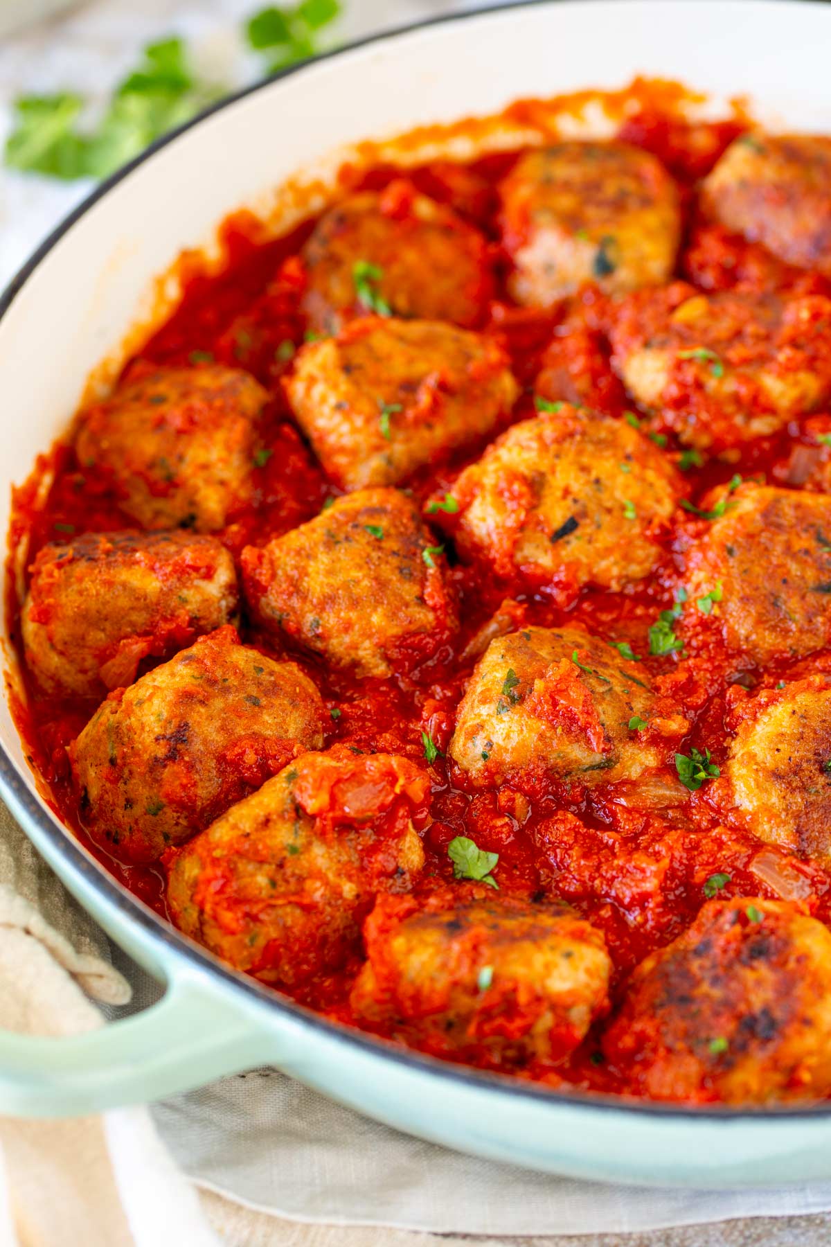 Close-up of chicken meatballs in tomato sauce in skillet