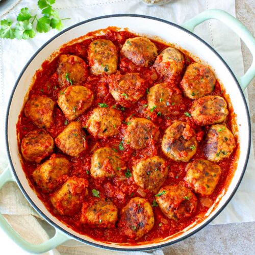 overhead of a skillet full of meatballs in tomato sauce