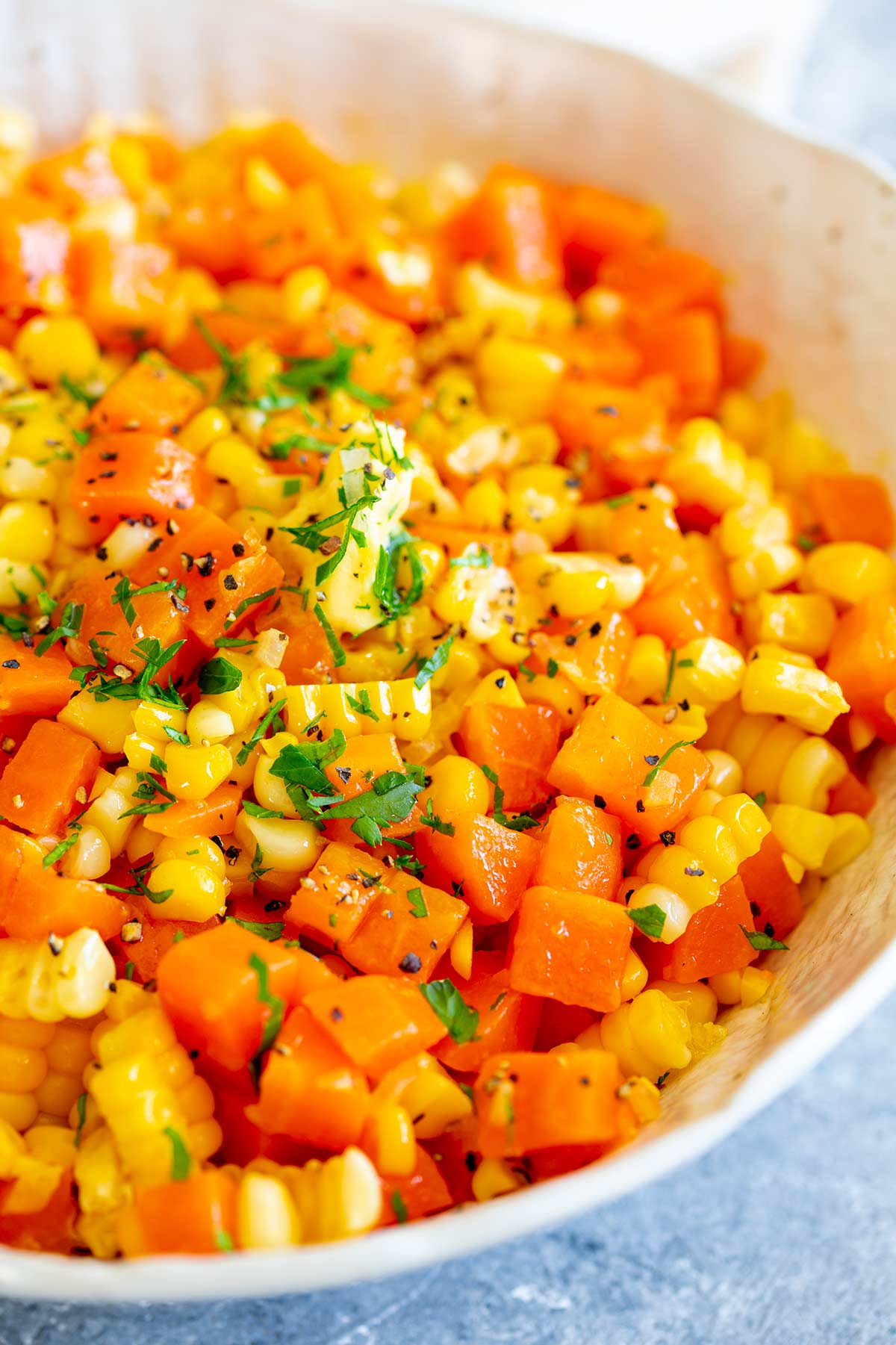 chopped carrots and corn garnished with parsley and pepper