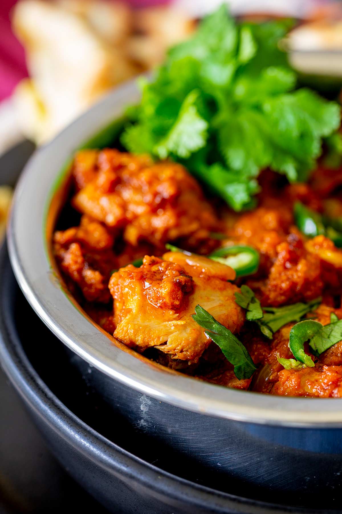 a large chunk of chicken in karahi sauce