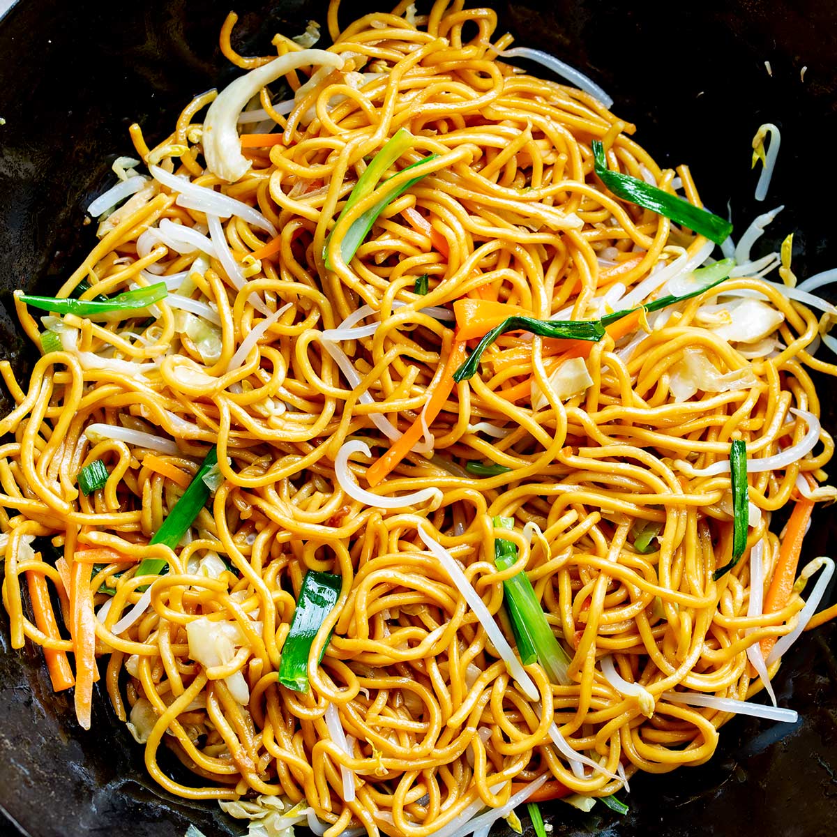 covered head of chow Mein noodles in a wok