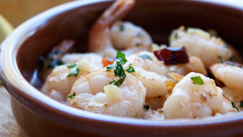 Gambas Pil Pil. A delicious dish of prawns (shrimps) in a wonderful garlic and chilli olive oil. Perfect tapas.