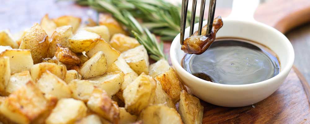 Salt and Vinegar Potato Cubes with Rosemary Balsamic Dip. These potatoes are a mix between a bag chips from the chippy and the Sunday roast potato. They are lightly crispy with a wonderful tang of salt and vinegar.