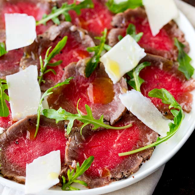 Close up on the peppered edges of the beef carpaccio