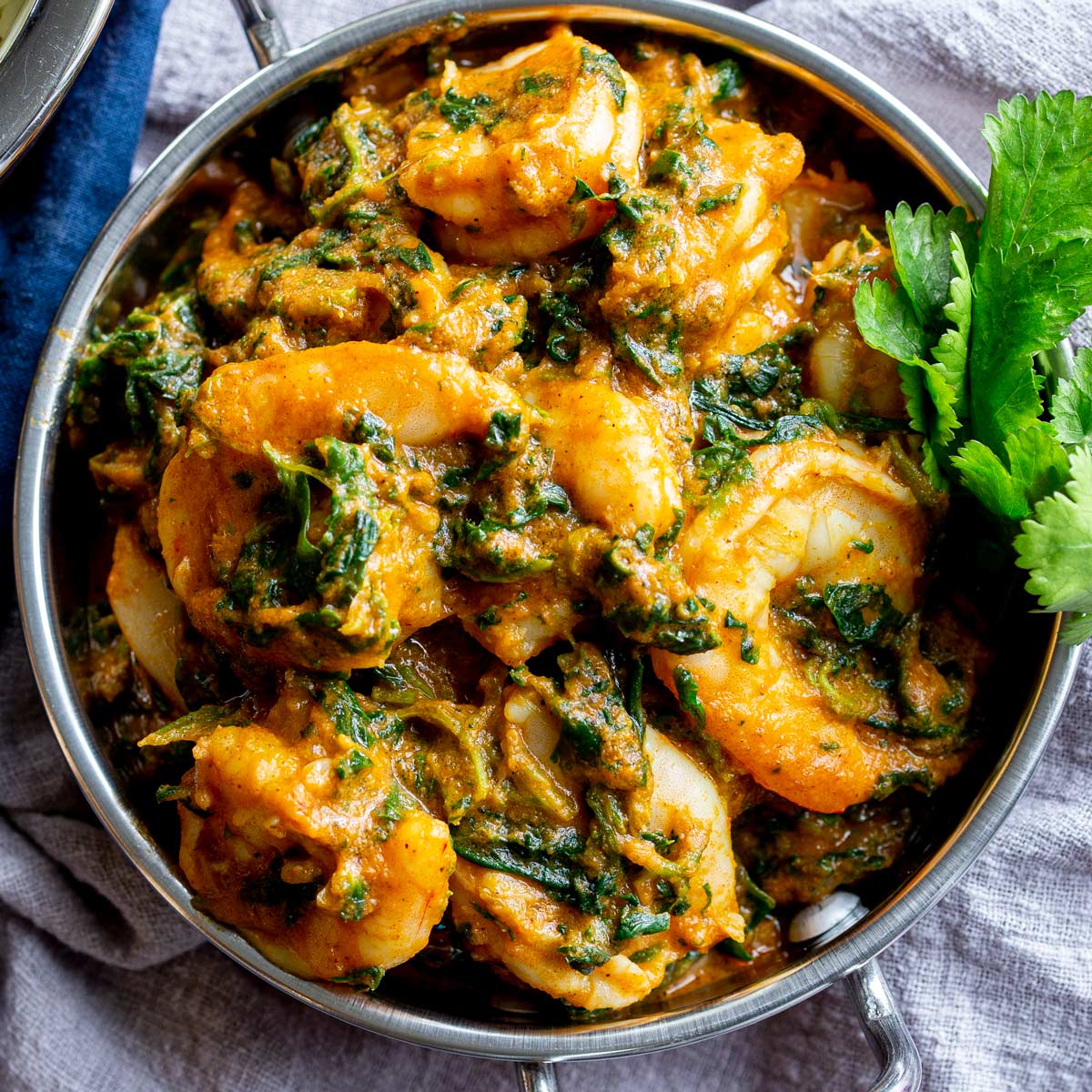 close up of peeled shrimp in a spinach curry